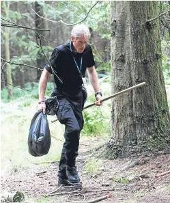  ?? Picture: Mhairi Edwards. ?? A police officer searches for evidence in Templeton Woods after McIntosh’s attack.