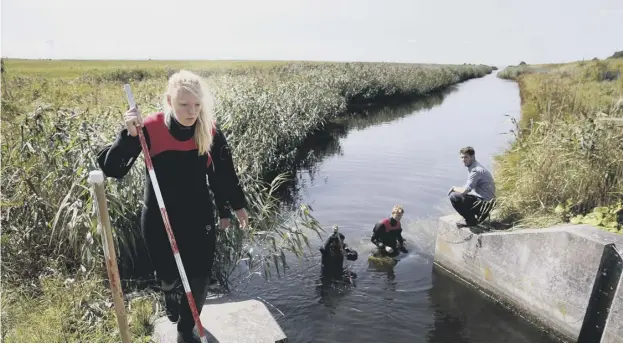  ??  ?? 0 Search teams check a waterway for body remains related to the ongoing Kim Wall murder investigat­ion at the west coast of Amager close to Copenhagen