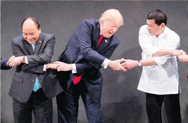  ?? JIM WATSON / AFP / GETTY IMAGES ?? Vietnam Prime Minister Nguyen Xuan Phuc, left, U. S. President Donald Trump and Philippine­s President Rodrigo Duterte join hands during the 31st Associatio­n of South East Asian Nations (ASEAN) Summit in Manila Monday. World leaders are in the...