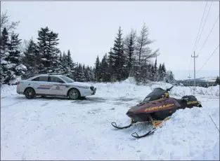  ?? DAVID MAHER/THE TELEGRAM ?? A rescuer’s snowmobile and an RCMP cruiser at the site of search efforts Wednesday afternoon at Mobile Big Pond.