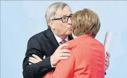  ?? LUKAS BARTH / EFE ?? Jean-Claude Juncker, president de la Comissió Europea, besa Angela Merkel, cancellera alemanya, ahir