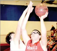  ?? RICK PECK/SPECIAL TO MCDONALD COUNTY PRESS ?? McDonald County’s Tim Shields scores while being defended by Seneca’s Cameron Brattin during the Mustangs’ 61-55 overtime loss on Jan. 12 at Seneca High School.