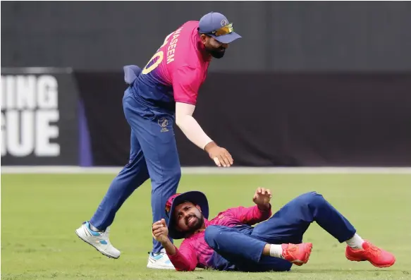  ?? Chris Whiteoak / The National ?? The UAE’s Basil Hameed is helped up by skipper Muhammad Waseem during their Cricket World Cup League 2 defeat to Canada in Dubai