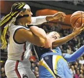  ?? Jessica Hill Associated Press ?? AALIYAH EDWARDS, left, and Chloe Marotta fight for the ball in Connecticu­t’s win over Marquette.