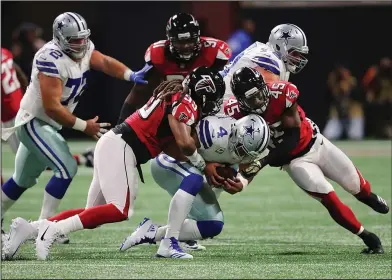  ??  ?? Sacked: Falcons defensive end Adrian Clayborn and linebacker Deion Jones sack Cowboys quarterbac­k Dak Prescott. Clayborn had six sacks in the Falcons' 27-7 win on Sunday in Atlanta.