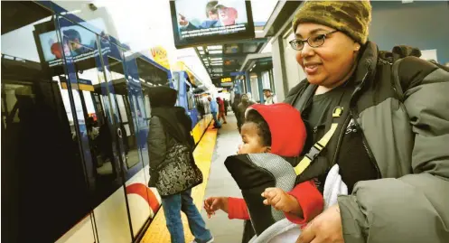  ??  ?? LaShay Thomas of St. Paul, and her great niece Nyanna Johnson, 10 months, prepare to board the Green Line on University and Snelling on Wednesday, March 9, 2016. The Snelling Green Line light rail transit stop is close to the United FC soccer stadium...