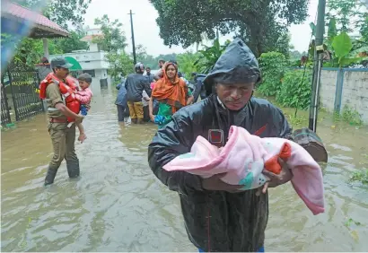  ?? Picture: AFP ?? SAFE HANDS. Fire and Rescue personnel evacuate children and other residents from a flooded area at Muppathada­m, Kochi’s Ernakulam district, in the Indian state of Kerala, yesterday. Indian authoritie­s have suspended all flights at Kochi internatio­nal airport until August 26.