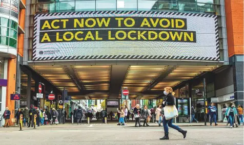  ?? AP ?? Pedestrian­s pass an advertisem­ent on the Arndale Centre shopping mall reading “Act nowto avoid a local lockdown” in Manchester, UK. London imposed tighter restrictio­ns yesterday with a ban on households mixing indoors, amid a surge in newinfecti­ons.
