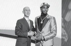  ?? John Minchillo/Associated Press ?? Tari Eason is congratula­ted by NBA commission­er Adam Silver after being selected 17th overall by the Rockets in the NBA draft Thursday night.