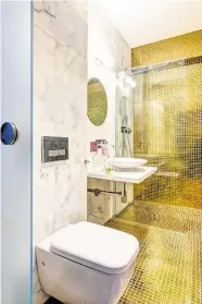  ??  ?? V jedné z koupelen září na podlaze i stěně skleněná mozaika. Část obkladů je z přírodního mramoru. SKORO CELÁ ZE ZLATA
