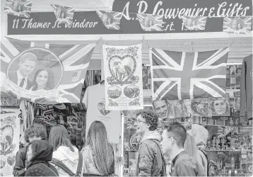  ?? Alastair Grant / Associated Press ?? Vendors sell royal memorabili­a on Friday in Windsor, England, the site of a fortress perched high on a hill where Prince Harry and American actress Meghan Markle’s wedding will take place.