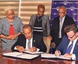  ??  ?? President of the Port Authority of Jamaica (PAJ), Professor Gordon Shirley (seated left), and vicepresid­ent of business developmen­t and client relations for Canada-based maritime company, Ocean Kevin Nichol (seated right), sign a 10-year concession agreement to provide towage services at the Port of Kingtson. The signing took place on Monday at the PAJ offices, downtown Kingston. Overseeing the signing (standing from left) are Property Manager, Legal Services, PAJ, Lois Pinnock; senior vice-president of finance and accounts, PAJ, Elva Richards; and vice-president of marine services and harbour master, Captain Hopeton Delisser.
