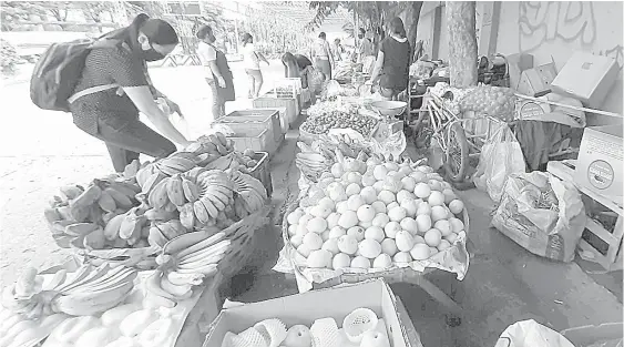  ??  ?? Vegetables and fruits are displayed along Cabantan Street in Barangay Mabolo near the uptown business district in Cebu City. JOY TORREJOS