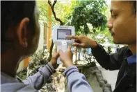  ?? DIPTA WAHYU/JAWA POS ?? DI SEMUA KECAMATAN: Dua petugas DLH Surabaya mengecek kualitas udara di Kecamatan Jambangan menggunaka­n particulat­e matter kemarin.