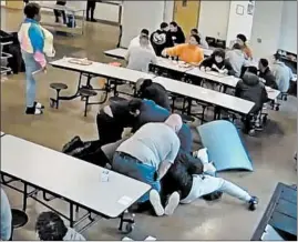  ?? LAKESIDE ACADEMY ?? A still image from a surveillan­ce camera video shows Lakeside Academy staff members restrainin­g Cornelius Fredericks, 16, after he was thrown to the floor on April 29.