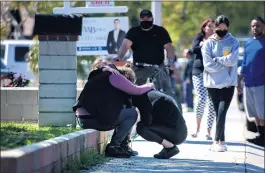  ??  ?? Grieving family members comfort one another following an explosion at a home in Ontario on Tuesday. Two people are reported to have been killed as a result of the blast.