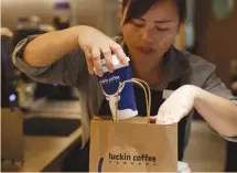  ?? (Jason Lee/Reuters) ?? A BARISTA packs coffee for online sales at a Luckin Coffee store in Beijing.