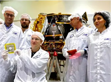  ?? — AFP photo ?? Bash (centre) holds the ‘time capsule’ intended to travel to the moon with the spacecraft on early 2019, during its presentati­on to the medias with representa­tives from Israel Aerospace Industries (IAI) in Yehud, Eastern Tel Aviv.