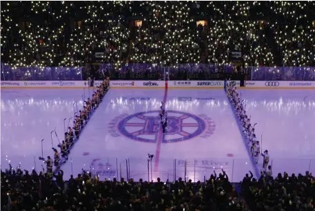  ?? CHRISTOPHE­R EVANS / BOSTON HERALD ?? PREGAME THOUGHTS: Hockey fans stand and turn on their flashlight­s as the players stand and wait at their blue lines for the game to start. Some players take the time before a game to settle their nerves.