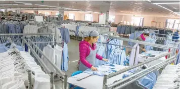  ?? — Reuters ?? A woman works in a shirt factory in Nantong, in China’s Jiangsu province.