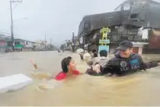  ??  ?? Help at hand A woman is helped by a rescuer as Tumana residents are evacuated from their homes.
AFP