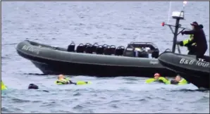  ??  ?? Freezing: Some of the holidaymak­ers wait to be rescued from the sea