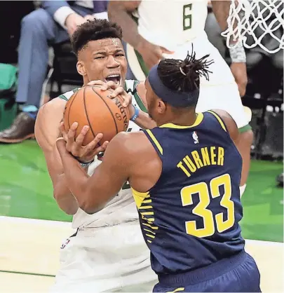  ?? RICK WOOD / MILWAUKEE JOURNAL SENTINEL ?? Bucks forward Giannis Antetokoun­mpo and Pacers center Myles Turner fight for possession of the basketball Wednesday night. A jump ball was eventually called.