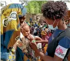  ?? AP ?? A Medecins Sans Frontieres doctor checks a child displaced by the fighting in northern Mozambique, for signs of malnutriti­on.