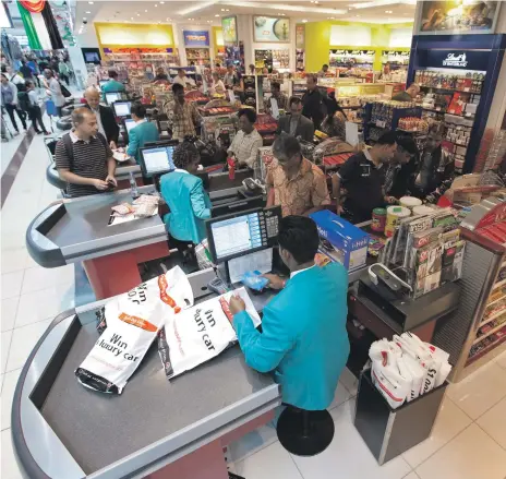 ?? Jeff Topping / The National ?? Checkout lines at a Dubai Duty Free store in Terminal 3. Perfumes have been the biggest-selling items this year