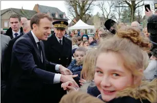  ?? AFP ?? President Macron shakes hands with residents before visiting a migrant centre in Croisilles, northern France, on Tuesday. —