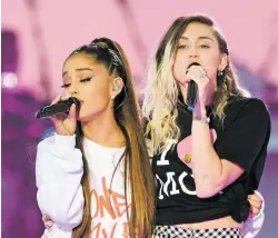  ?? DAVE HOGAN VIA ASSOCIATED PRESS ?? Ariana Grande, left, and Miley Cyrus perform at the One Love Manchester tribute concert Sunday in Manchester, north western England. The concert raised $13 million for an emergency fund for victims of a suicide bombing May 22 at Grande’s Manchester...