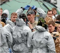  ??  ?? Military personnel are prepared before working to remove cars from a car park in Salisbury, England, as the investigat­ion continues into the suspected nerve agent attack on Sergei Skripal and his daughter Yulia.