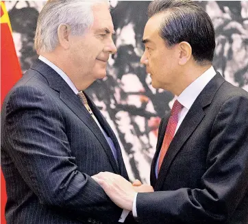  ??  ?? TALKING IT BACK, YET AGAIN: Secretary of State Rex Tillerson (left) meets with Chinese Foreign Minister Wang Yi on Saturday in Beijing, where the United States’ top diplomat played down the latest tweet by President Trump that bashed foreign leaders.