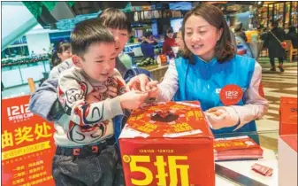  ?? DOU YIMING / FOR CHINA DAILY ?? Buyers draw a lottery, which was hosted by Alipay in a department store in Xi’an, Shaanxi province.