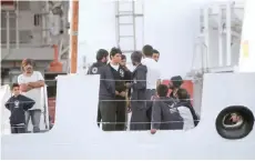  ?? — AFP ?? Migrants stand on the bridge of Italy’s Diciotti coast guard vessel carrying 67 asylum seekers berthed at Trapani port.