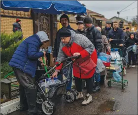  ?? (AP/Bernat Armangue) ?? Residents line up to fill containers with drinking water Sunday in Kherson, Ukraine.