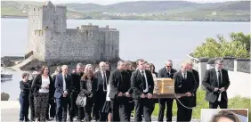  ??  ?? > Roddy MacLeod, father of Manchester bomb victim Eilidh MacLeod, leads the funeral procession as it passes Kisimul Castle on the island of Barra. Right, Eilidh