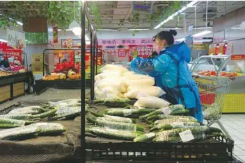  ??  ?? An employee sorts vegetables inside a supermarke­t in Wuhan, the epicentre of the novel coronaviru­s outbreak, in Hubei province, China, yesterday.