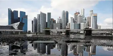  ?? ?? Slower pace: The Singapore skyline is set against gathering storm clouds. The city-state has ruled out a recession but says gross domestic product growth next year will probably fall to between 0.5% and 2.5%. — Reuters
