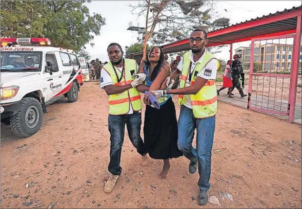  ?? CARL DE SOUZA / AFP ?? Personal sanitario ayuda a una mujer herida durante el asalto del grupo fundamenta­lista somalí Al Shabab en la Universida­d de Garissa