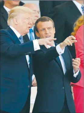  ?? AP/MICHEL EULER ?? French President Emmanuel Macron (right) and U.S. President Donald Trump talk Friday as they watch the traditiona­l Bastille Day military parade on the Champs Elysees, in Paris.