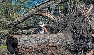  ?? SCOTT CLAUSE/THE DAILY ADVERTISER ?? Michael McDonald clears trees Saturday after Hurricane Delta passed through the area in Jennings, Louisiana.