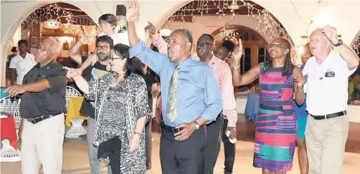  ??  ?? Dr Robert Leger, Governor of Rotary Internatio­nal’s District 7020 (centre) and members of the Rotary Clubs of Lucea and Negril sing ‘One Love’, which was being played by the Charela Inn’s resident band on Thursday night.