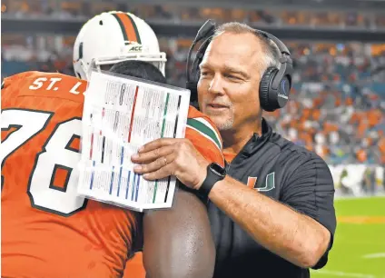  ?? STEVE MITCHELL/USA TODAY SPORTS ?? Miami coach Mark Richt, talking with offensive lineman Tyree St. Louis, has the Hurricanes 9-0 and No. 2 in the country.