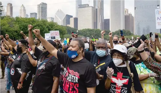  ?? PAT NABONG/SUN-TIMES FILE PHOTO ?? Community activists raise their fists during a march to commemorat­e Juneteenth in downtown Chicago on June 19.