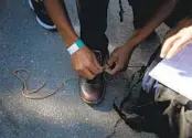  ?? ?? A migrant from Nicaragua laces his shoes after being dropped off at the welcome center last month.