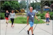  ?? MICHILEA PATTERSON — DIGITAL FIRST MEDIA ?? People use skiing poles to try out Nordic Walking during a seminar at Pottstown Middle School.