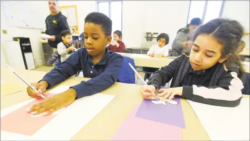  ?? Matthew Brown / Hearst Connecticu­t Media ?? Amare and Mia, first-graders from Bridgeport’s Read Elementary School, draw shapes for a collage that they are creating during a Mingled Arts program at the Greenwich Art Society studio in Greenwich on March 29.