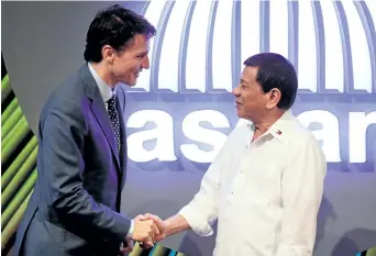  ?? MARK R. CRISTINO/GETTY IMAGES ?? Prime Minister Justin Trudeau shakes hands with Philippine President Rodrigo Duterte, right, before the opening ceremony of the 31st Associatio­n of Southeast Asian Nations (ASEAN) Summit in Manila on Monday.