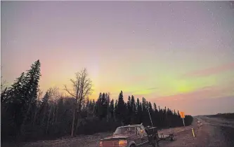  ?? JONATHAN HAYWARD THE CANADIAN PRESS ?? The northern lights shine above the glow from a wildfire in northern Alberta, which is part of Canada’s boreal forest.